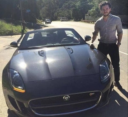 A picture of Kit Harington with his black 2019 Infiniti Q60.